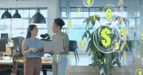 Diverse businesswomen collaborating with finance technology in office