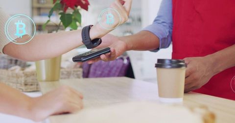Customer tapping smartwatch for bitcoin contactless payment at cafe counter with barista