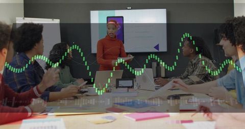 Young woman presenting business strategy to diverse team with financial chart overlays
