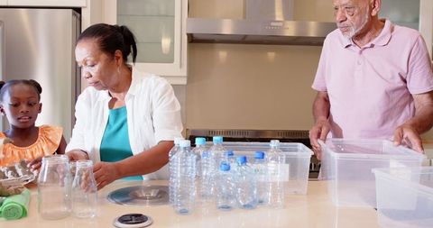 Family Sorting Plastic Bottles for Recycling in Home Kitchen