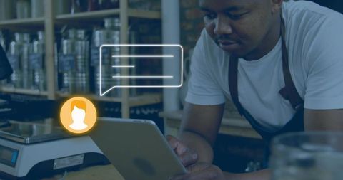 Barista checking tablet with messaging overlay in rustic industrial coffee shop