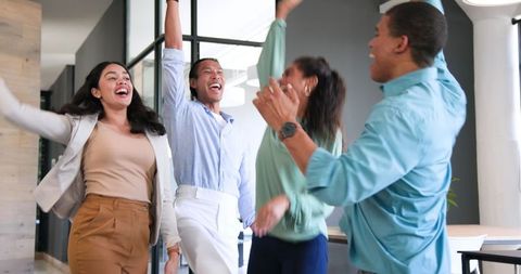 Cheerful Diverse Team Celebrating in Office Environment