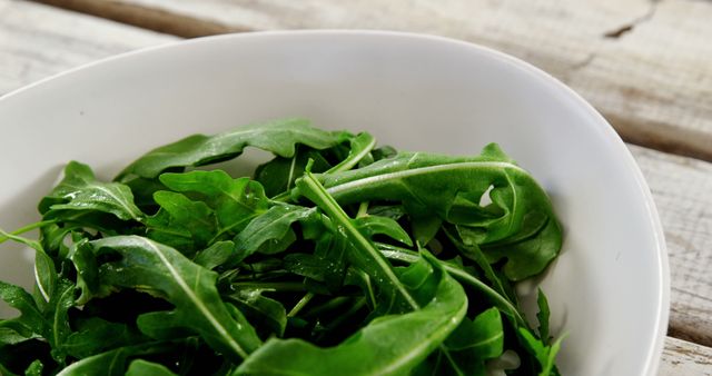 Fresh Green Arugula Leaves in White Bowl on Wooden Table - Download Free Stock Images Pikwizard.com