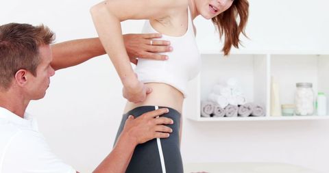 Physiotherapist Assists Female Patient with Rehabilitation Exercise