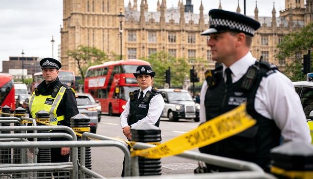 London met police officers managing westminster cordon and traffic by parliament building