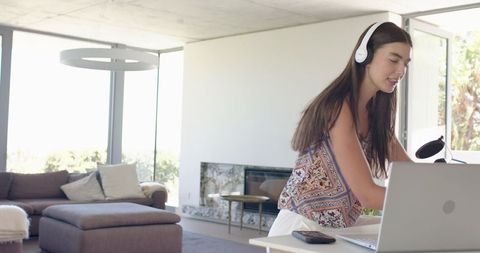 Teenage Girl Listening to Music on Headphones in Modern Living Room