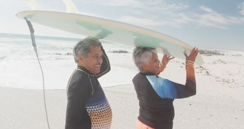 Senior Couple Enjoying Surfing on Sunny Beach Day