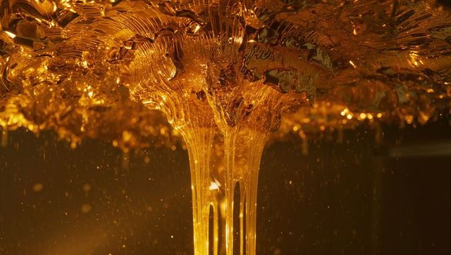 Golden liquid flowing in studio as abstract art