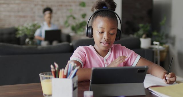 Young African American Girl Studying at Home Using Tablet and Headphones - Download Free Stock Images Pikwizard.com