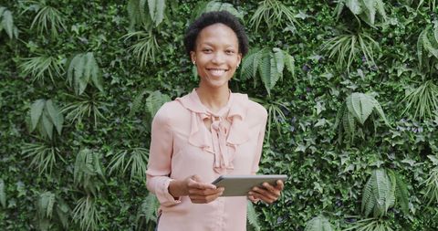 Smiling African American Businesswoman Holding Tablet in Leafy Outdoor Space