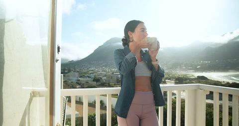 Woman Enjoying Morning Coffee on Scenic Coastal Balcony