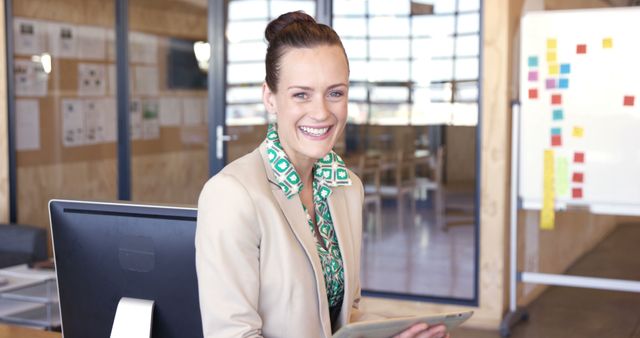 Businesswoman Smiling at Desk in Modern Office Environment - Download Free Stock Images Pikwizard.com