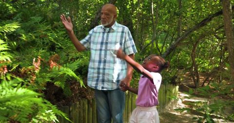 Grandfather Enjoying Forest Walk with Granddaughter Hand in Hand