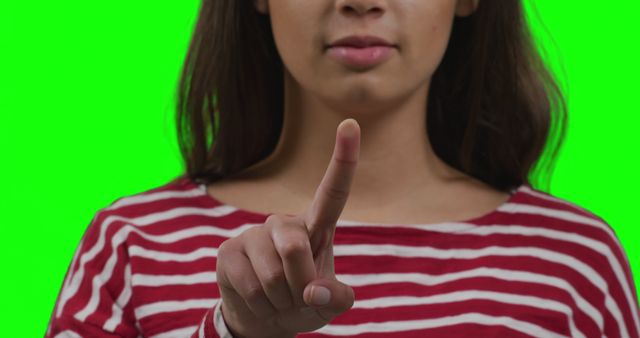 Woman Pointing Finger on Green Background Wearing Striped Shirt - Download Free Stock Images Pikwizard.com