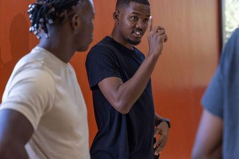 African american men having animated discussion in wood-walled workspace, casual