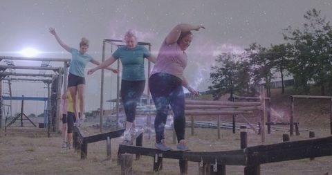 Diverse group of women balancing on obstacle course