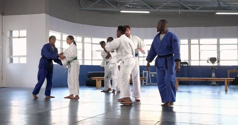Judo Class in Progress: Practicing Throws and Techniques in Dojo