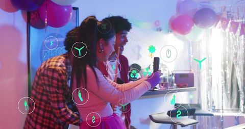 Young friends taking neon selfie with AR icons among pink balloons and party fringe