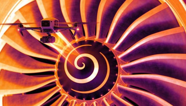 Inspection drone hovering over turbofan blades scanning spinner spiral with gimbal camera