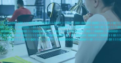 Joining remote video call in open office with laptop showing colleague and data overlay