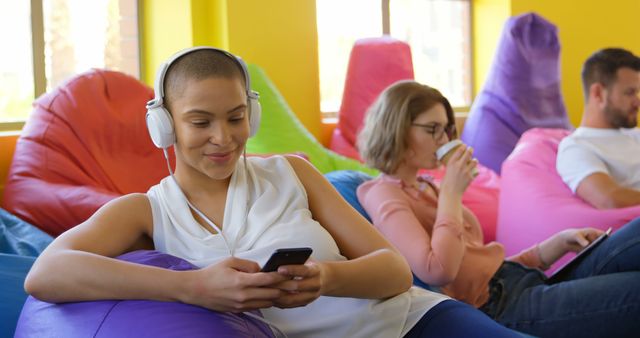 Young Professionals Relaxing with Technology in Modern Office Lounge - Download Free Stock Images Pikwizard.com