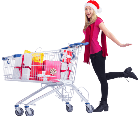Cheerful woman in santa hat with transparent shopping cart full of gifts