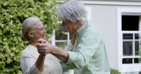 Senior Couple Dancing Joyfully in Garden Embracing Companionship
