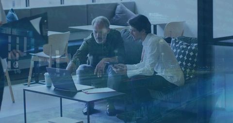 Collaborative work in modern office lounge with laptop and phone