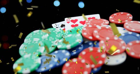 Confetti falling over playing cards and gambling chips