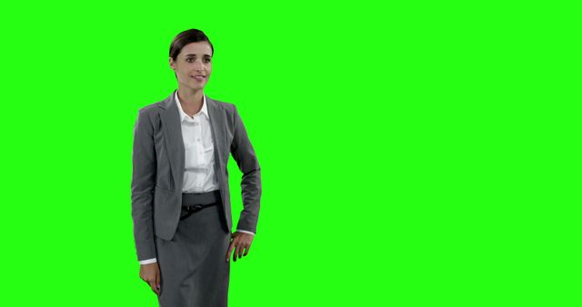 Professional woman dressed in business attire standing confidently against a green screen background. Ideal for corporate presentations, business advertisements, photo montages, marketing materials, and various digital media projects that require an isolated figure to be easily placed over different backgrounds or designs.