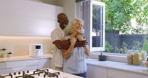 Senior couple embracing in a modern kitchen setting