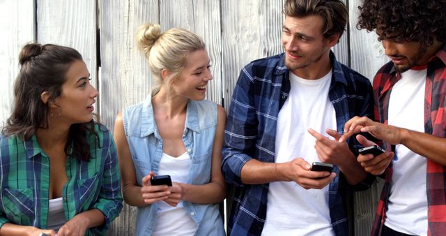 Group of Young Adults Socializing and Using Smartphones Outdoors - Download Free Stock Images Pikwizard.com