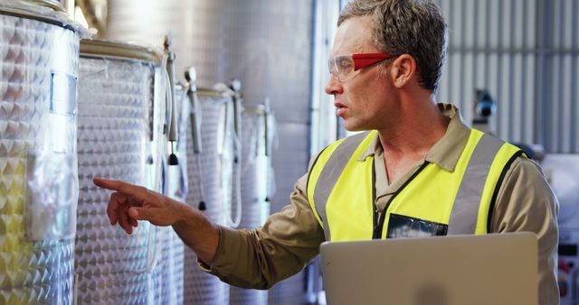 Male Factory Worker Examining Equipment While Using Laptop - Download Free Stock Images Pikwizard.com