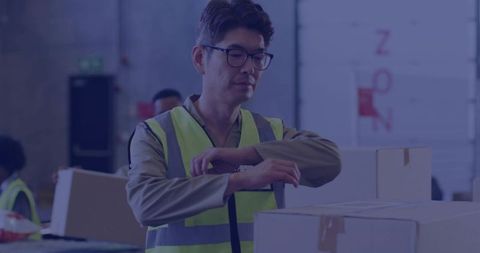 Asian Warehouse Worker Checking Wristwatch While Inspecting Boxes at Fulfillment Station
