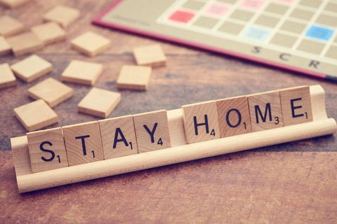 Stay Home Message with Board Game Tiles on Wooden Surface