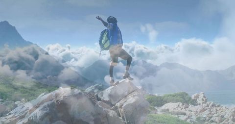 Triumphant Hiker Celebrating Summit with Arms Raised on Rocky Mountain