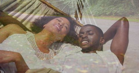 Couple relaxing in woven hammock on sunlit beach, romantic seaside getaway with leaf overlay