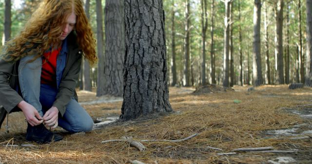 Woman Tying Hiking Boot in Forest Clearing with Pine Trees - Download Free Stock Images Pikwizard.com