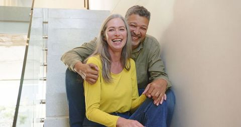 Smiling Senior Couple Embracing on Indoor Staircase