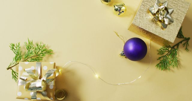 Image of gold and purple christmas decorations and presents on yellow background. christmas, tradition and celebration concept.