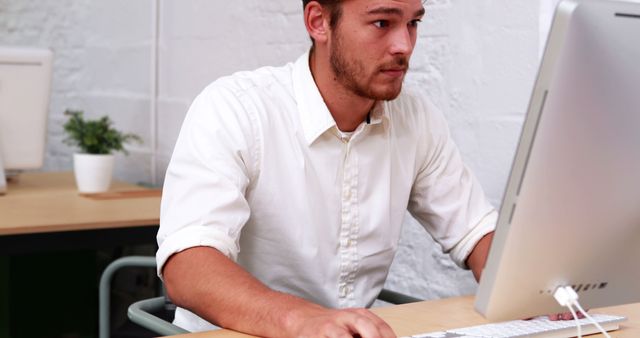 Focused Young Man Working on Desktop Computer in Modern Office - Download Free Stock Images Pikwizard.com