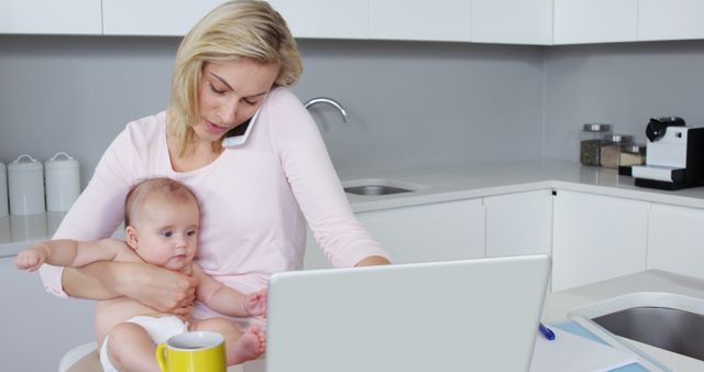 Busy Mother Multitasking with Baby and Laptop in Modern Kitchen - Download Free Stock Images Pikwizard.com