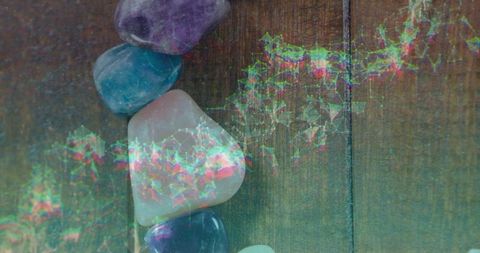 Polished gemstones with digital overlay on wooden surface