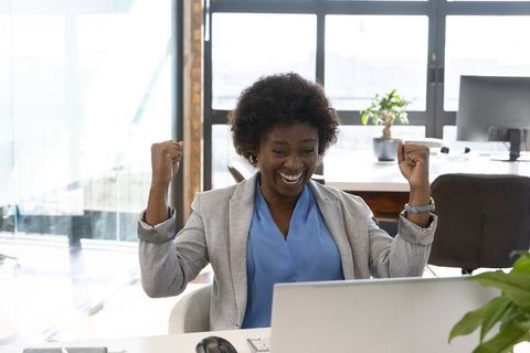 Ecstatic Business Woman Celebrating Success at Workplace