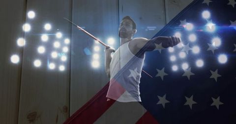 Male javelin thrower powering throw under stadium lights with american flag overlay