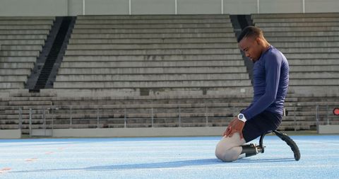 Determined paralympic athlete stretching on track field
