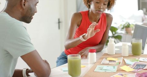 Couple planning wellness routine with supplements and green smoothies at home