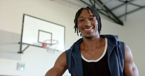 Smiling Athlete Enjoying Basketball in Gym