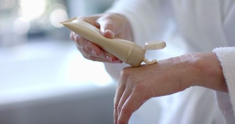 Mature Woman Applying Lotion for Skincare Routine