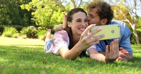 Couple taking selfie on sunny day in park